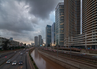 Fototapeta na wymiar Cloudy gloomy Tel Aviv city before the sunset. Modern glass skyscrapers and automobile Ayalon highway