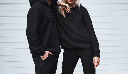 Basic clothing brand mockup. Design template for hoodie and casual sportswear. A woman and man wearing hoodies with no logo. Horizontal sweatshirt mock-up