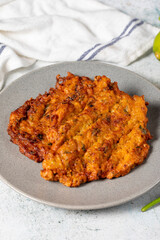 Mucver on the gray background. Frying dinner made of pumpkin. Close up