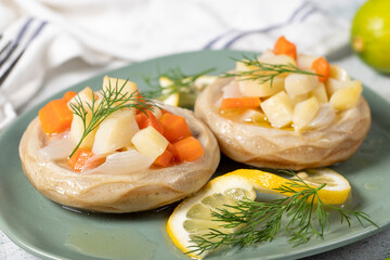 Artichoke with vegetables on gray floor. Artichoke dinner made with olive oil, potatoes, carrots and onions. Healthy food. Close up