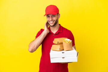 pizza delivery man picking up pizza boxes and burgers over isolated background laughing
