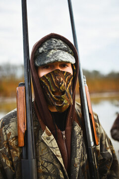 A man holds shotguns