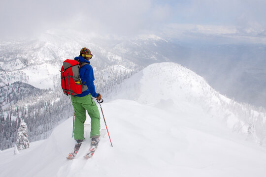 A backcountry skier at the top of a ridge near Columbia Falls, Montana.