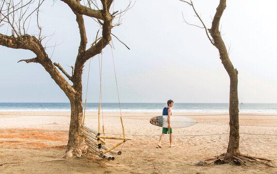 A Male Surfer Walks On The Beach Towards The Waves At Popoyo Beach, Nicaragua