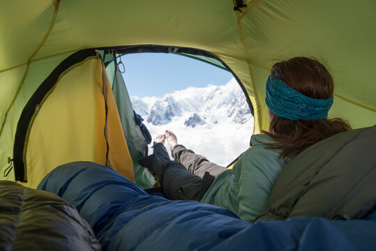 A woman looks out at the view of the mountains of Denali National Park while camping on the Ruth Glacier in Alaska.