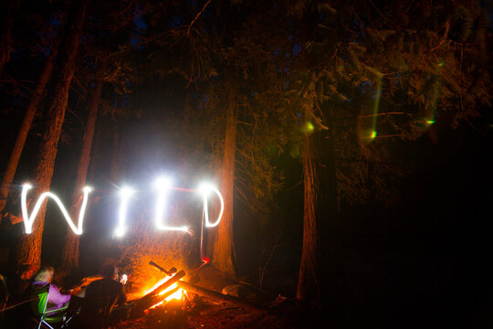A nighttime light-painted message says "Wild" above a campfire near Eureka, Montana.