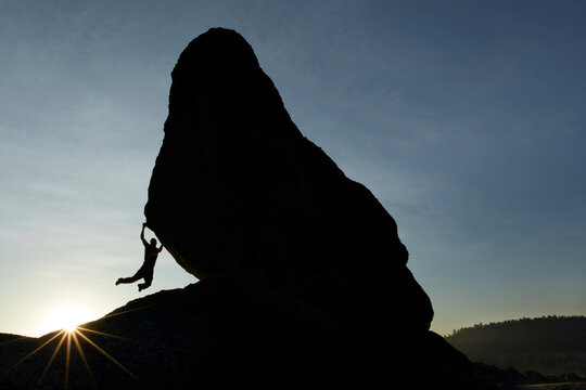 Climber climbing on boulder at in Valley of Frogs near Creel, Chihuahua, Mexico
