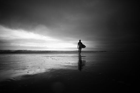 Surfer walks out to catch another wave
