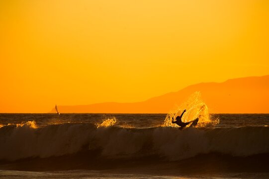 Surfer blows tail at sunset