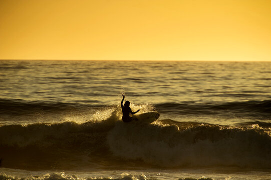 Surfer hits the lip at sunset