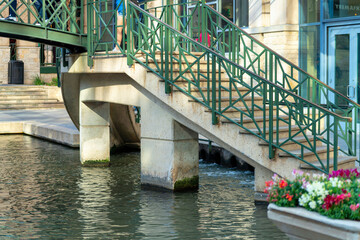 Steps and stairs by water front in san antonio texas in afternoon shade with green hand rails and...