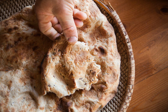 A man graps a piece of flatbread at his home in Ezuz, Israel.