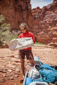 A woman studies a map besides her canoe at the mouth of Horse Canyon, Canyonlands National Park, Utah.