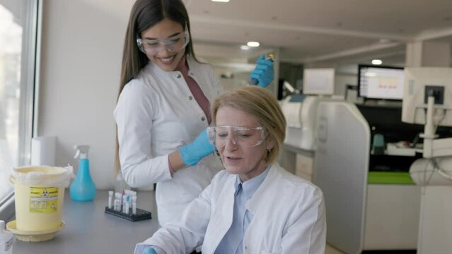 Modern Medical Research Laboratory: Two Scientists Working Together Analysing Chemicals in Laboratory, Discussing Problem. Advanced Scientific Lab for Medicine, Biotechnology, Molecular Biology
