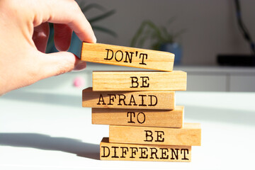 Wooden blocks with words 'Don't Be Afraid to Be Different'.