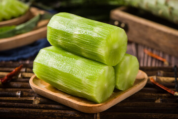 Fresh peeled asparagus lettuce on wooden table.