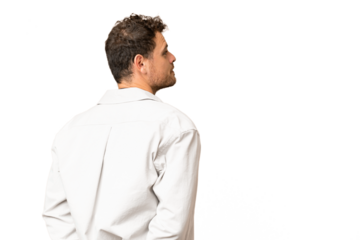 Brazilian man over isolated chroma key background in back position and looking back