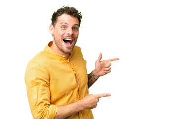 Brazilian man over isolated chroma key background surprised and pointing side