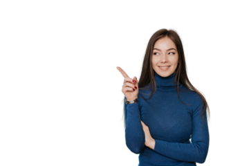 Beautiful European girl with long loose hair in a blue sweater points by  her index finger to the side, to an empty place, on transparent background looks at imaginary object. Promo, mockup, discount.
