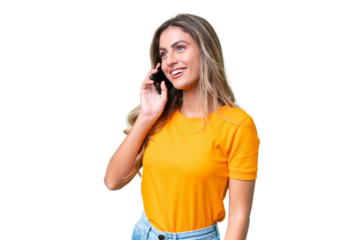 Young Uruguayan woman over isolated background keeping a conversation with the mobile phone