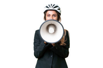 Business Uruguayan woman wearing a helmet biker over isolated background shouting through a megaphone