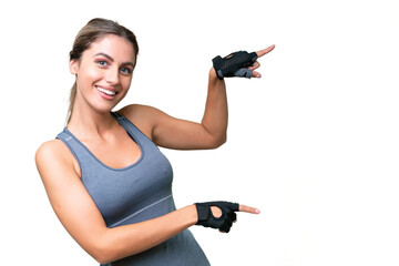 pretty Sport Uruguayan woman over isolated background pointing finger to the side and presenting a product