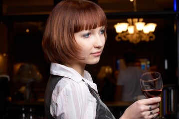 Young woman drinking red wine in bar