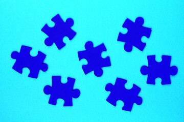 Fototapeta premium Blue mosaic game details of jigsaw puzzle elements on blue background. Completing task or solving problem concept. World mental health day, autism awareness day. Global communication. Hobby, play
