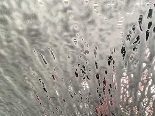 Washing foam on the car window. Car wash abstract background.  Jet spraying to car