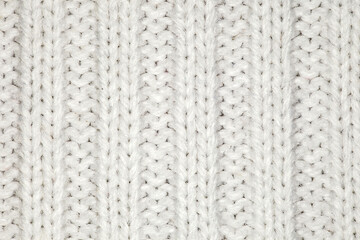 Fabric knitted with white yarn threads, background wallpaper, uniform texture pattern