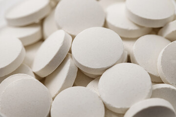 Tablets round white medical, medicines many in bulk, selective focus