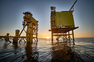 View of Offshore electrical distribution station for wind farms in the sunset at sea.