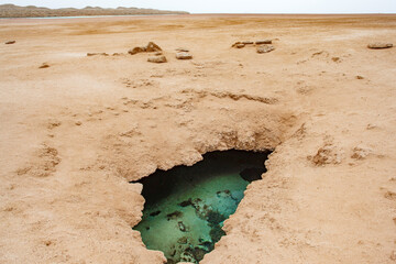 Geological faults of earth filled, hole filled with turquoise water, result of earthquakes