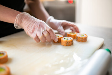 professional chef's hands making sushi and rolls in a restaurant kitchen
