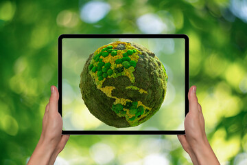 Hands holding digital tablet with green planet Earth on a screen