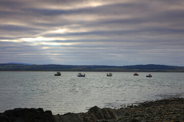 Image of small fishing boats moored in a harbour at Lindisfarne, Holy Island, Northumberland, England, UK.