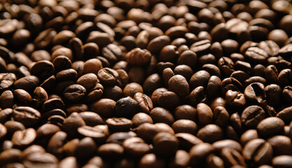 Roasted coffee beans in close up. Wide background with dark roast caffeine grain