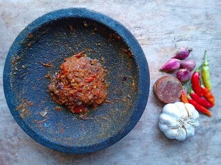 Sambal is a spicy traditional food from Indonesia made from chillies. Sambal on wood background