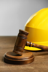 Construction and land law concepts. Gavel and hard hat on wooden table