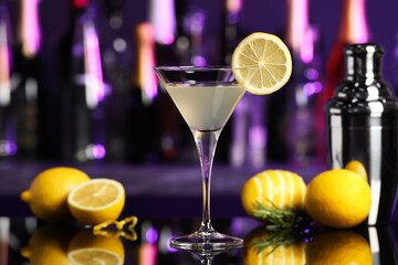 Martini glass of refreshing cocktail, shaker and lemon on mirror surface