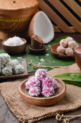 Obraz na płótnie Canvas Klepon or kelepon, is a snack of sweet rice cake balls filled with molten palm sugar and coated in grated coconut.