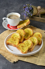 Tasty bread with garlic, cheese and herbs on kitchen table
