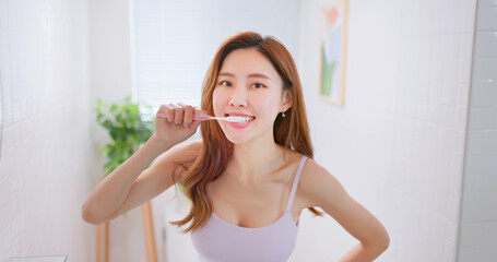 asian smiling woman brush teeth