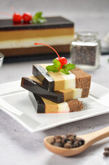 Layered dessert Trifles in a transparent glass. Sponge biscuit and three chocolate mousse layers. Chocolate souffle trifle cake in individual disposable transparent cups. White background