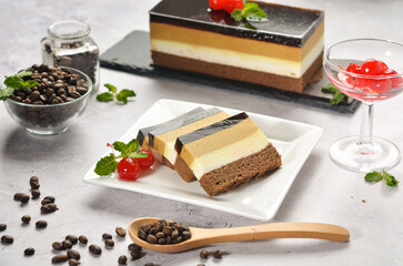 Layered dessert Trifles in a transparent glass. Sponge biscuit and three chocolate mousse layers. Chocolate souffle trifle cake in individual disposable transparent cups. White background