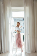 a woman in a pink skirt stands at the door in the room