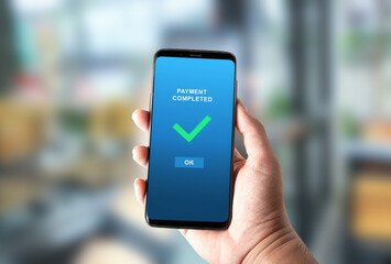payment completed notification in a mobile phone screen on bright blurred background