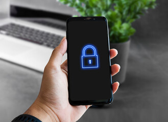 hand holding smartphone with virtual lock system icon symbol. networking security concept