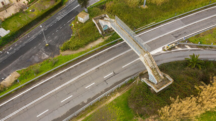 Aerial view of a pedestrian bridge crossing a high-speed road.