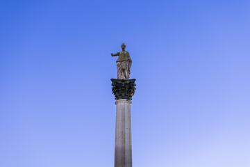 Statue of Minerva on the Colonna di Minerva and Galleria degli Antichi against the blue sky. Sabbioneta, Lombardy, Italy